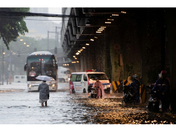 In this photo taken on July 22, 2025, pedestrians wade through a flooded street caused by heavy rains in Manila. Photo by Ted ALJIBE / AFP