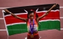 First placed Kenya's athlete Beatrice Chebet celebrates with her country's flag at the end of the women's 10000m final during the World Athletics Championships in Tokyo on September 13, 2025. (Photo by Yuichi Yamazaki / AFP)
