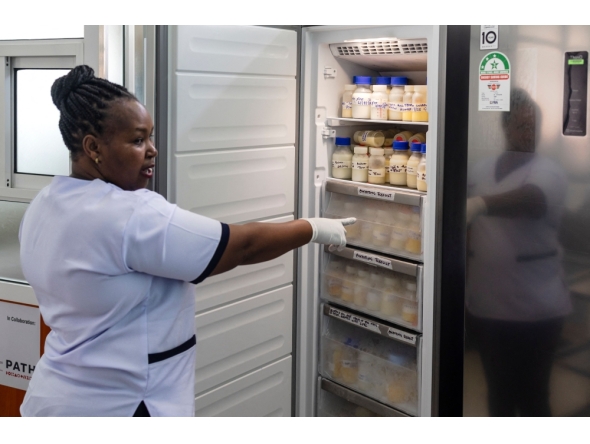 Hannah Wangeci Maina, a senior nurse gestures towards reserves donated breastmilk preserved in a freezer to await screening at a human milk bank in the Pumwani Maternity Hospital, Nairobi on September 04, 2025. (Photo by Tony Karumba / AFP)
