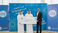 Fatima Mohamed Al-Ansari’s brother receiving the grand prize from QIB officials.
