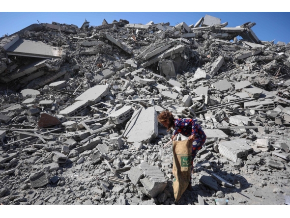 A Palestinian girl searches the rubble of al-Ghafari tower after its destruction by Israeli airstrikes in Gaza City on September 15, 2025. (Photo by Omar AL-QATTAA / AFP)
