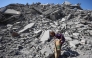 A Palestinian girl searches the rubble of al-Ghafari tower after its destruction by Israeli airstrikes in Gaza City on September 15, 2025. (Photo by Omar AL-QATTAA / AFP)
