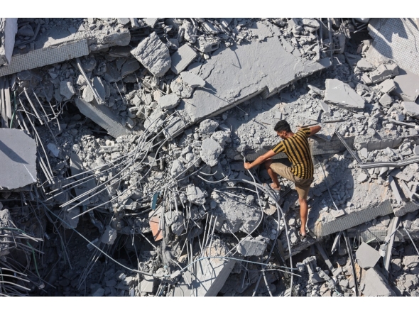 A Palestinian youth climbs the rubble of al-Ghafari tower after its destruction by Israeli airstrikes in Gaza City on September 15, 2025. Photo by Omar AL-QATTAA / AFP