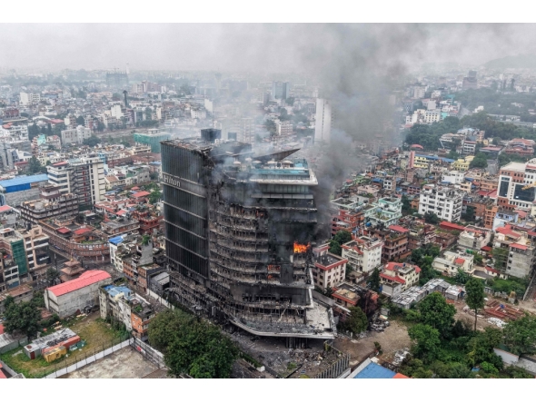 Smoke billows from the burning Hilton Hotels, a day after it was set ablaze by protesters in Kathmandu on September 10, 2025. (Photo by Prabin Ranabhat / AFP)

