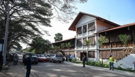 A view of people standing in front of the contemporary arts museum called the House of Art, a former post office and customs building, a remnant of the colonial era, of the Societe General Cote d'Ivoire (SGBCI) foundation in Grand-Bassam, a city listed as a UNESCO World Heritage Site, on September 25, 2025. (Photo by Sia KAMBOU / AFP)