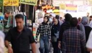 Iranians walk along a busy street in Tehran on September 28, 2025. (Photo by Atta Kenare / AFP)