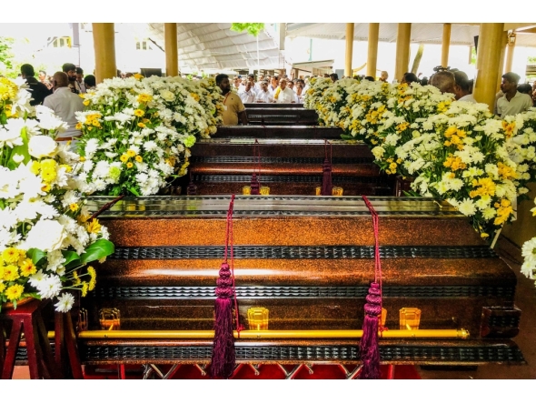 People gather near the coffins of Buddhist monks during a funeral ceremony at the Na Uyana Monastery in Melsiripura on September 27, 2025. (Photo by AFP)