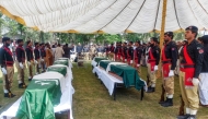 Policemen stand by the coffins of slain police personnel during a funeral ceremony at Dera Ismail Khan in Khyber Pakhtunkhwa province on October 11, 2025. (Photo by Mohammad Kashif / AFP)
 
