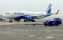 (Files) Ground staff walk past an Indigo airlines aircraft taxiing in the apron at the Netaji Subhash Chandra Bose International airport in Kolkata on February 1, 2024. (Photo by Indranil Mukherjee / AFP)