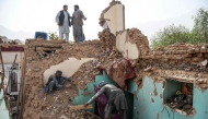 Afghan earthquake survivors search through the remains of a damaged house at a village in Tashqurghan, in the Khulm district of Samangan province on November 3, 2025. (Photo by Atif Aryan / AFP)