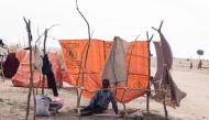 A displaced Sudanese man who fled El-Fasher after the city fell to the Rapid Support Forces (RSF), sits in a makeshift shelter in the Um Yanqur camp, located on the southwestern edge of Tawila, in war-torn Sudan's western Darfur region on November 3, 2025. (Photo by AFP)