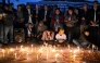 Family members of those killed in September anti-corruption protests take part in a candlelight vigil in front of the fire-damaged parliament building in Kathmandu on November 9, 2025. (Photo by Prakash Mathema / AFP)

