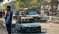 Policemen examine damaged vehicles after a suicide blast outside the district court in Islamabad on November 11, 2025. (Photo by Zain Zaman JANJUA / AFP)
