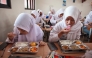 Students eat lunch on the first day of a free-meal program at 11 State Senior High School in East Jakarta on January 6, 2025. Photo by Aditya IRAWAN / AFP

