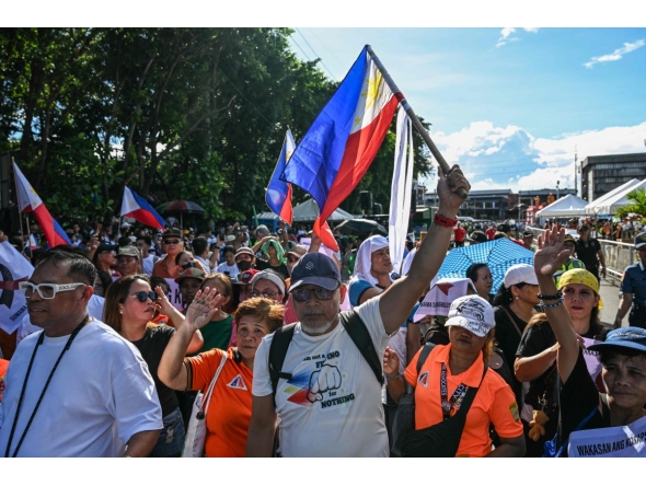 Protesters wave flags and shout slogans during an anti-corruption rally in Quezon City, Metro Manila on November 16, 2025. (Photo by Jam STA ROSA / AFP)