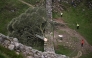 (Files) Police officers stand on duty at the edge of a cordon around the felled Sycamore Gap tree, along Hadrian's Wall, near Hexham, northern England on September 28, 2023. (Photo by Oli Scarff / AFP)