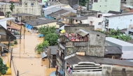 This handout photo taken and released by the Royal Thai Navy on November 26, 2025 shows people looking out from residential buildings surrounded by flood waters in Hat Yai. (Photo by Handout / Royal Thai Navy / AFP) 