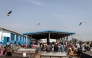 Seagulls fly over a fish market in Bissau, on November 26, 2025. (Photo by PATRICK MEINHARDT / AFP)
