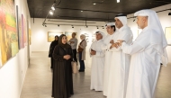 Officials and visitors view paintings on display at Katara during an exhibition held in connection with the FIFA Arab Cup Qatar 2025.   