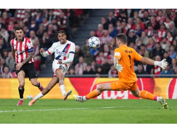 Paris Saint-Germain's French forward #29 Bradley Barcola challenges Athletic Bilbao's Spanish goalkeeper #01 Unai Simon during the UEFA Champions League league phase day 6 football match between Athletic Club Bilbao and Paris Saint-Germain (PSG) at San Mames Stadium in Bilbao on December 10, 2025. (Photo by Cesar MANSO / AFP)
