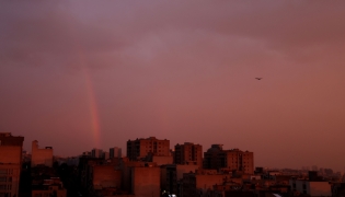 A general view of a rainbow at sunset following several days of rain in the Iranian capital Tehran on December 10, 2025. (Photo by Atta Kenare / AFP)