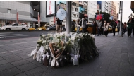 Flowers and notes from the public are laid for the victims of the metro attack outside a mall in Taipei on December 20, 2025. Taiwan's President Lai Ching-te pledged a full, public enquiry into a deadly metro stabbing attack as he visited victims in hospital on December 20. (Photo by Akio Wang / AFP)