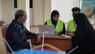 Electoral officials assist a voter at a polling station during local council elections in Mogadishu on December 25, 2025. (Photo by Hassan Ali ELMI / AFP)