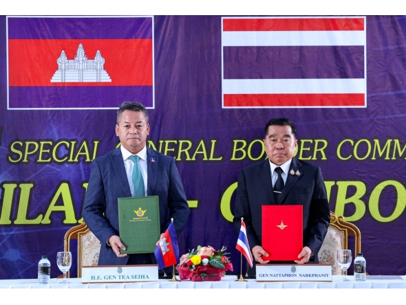 This handout photo released by Agence Kampuchea Press (AKP) on December 27, 2025 shows Cambodia's defence minister Tea Seiha (L) and Thailand's defence minister Nattaphon Narkphanit (R) posing with documents during the special General Border Committee (GBC) meeting at a border checkpoint in Thailand's Chanthaburi province. Photo by Agence Kampuchea Presse (AKP) / Agence Kampuchea Press (AKP) / AFP