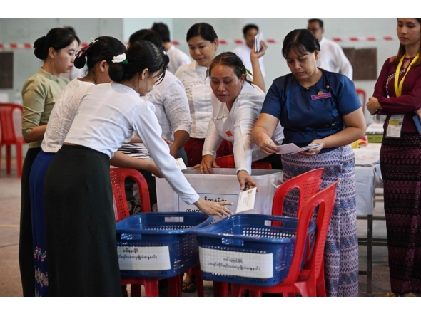 Members of Myanmar Union Election commission (UEC) count ballots after the closing of polls at a polling station in the first phase of Myanmar general election in Yangon on December 28, 2025. (Photo by Lillian Suwanrumpha/ AFP)