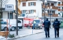 Police officers walk near ambulances at the site of an explosion that ripped through a bar in Crans-Montana on January 1, 2026.  (Photo by Maxime Schmid / AFP)