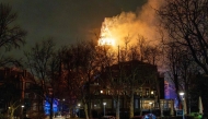 People look at the tower of the Vondelkerk church on fire during New Year's Eve, in Amsterdam on January 1, 2026. (Photo by Laurens Niezen / ANP / AFP)