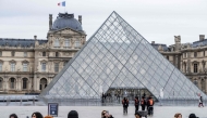 Tourists stand behind barriers blocking the access to the Louvre main courtyard, La Cour Napoleon, with the Louvre Pyramid, designed by Chinese-US architect Ieoh Ming Pei, as the Louvre Museum is closed due a strike, in Paris, on January 12, 2026. Photo by Martin LELIEVRE / AFP
