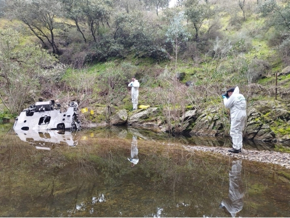 This handout photo taken and released on January 21, 2026 by the Spain's Guardia Civil, shows Guardia Civil agents taking photographs of a train bogie in a stream, near the site where on January 18 a high-speed Iryo train derailed and hit another train in Adamuz, southern Spain. (Photo by Handout / Guardia Civil / AFP)