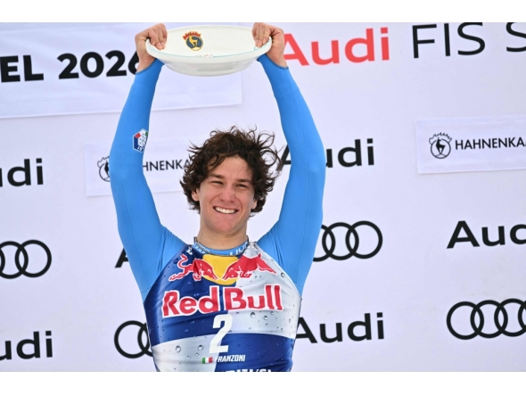 Winner Italy's Giovanni Franzoni celebrates on the podium with his trophy after the Men's Downhill event of the FIS Alpine Skiing World Cup in Kitzbuhel, Austria, on January 24, 2026. (Photo by Joe Klamar / AFP)