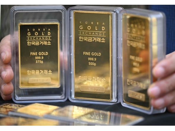 An employee displays gold bars at a store of the Korea Gold Exchange in Seoul on January 26, 2026. (Photo by Jung Yeon-je / AFP)