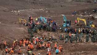 Rescuers search for victims buried by a landslide in Pasirlangu village in Bandung, West Java, on January 26, 2026. (Photo by Timur Matahari / AFP)