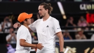 Germany's Alexander Zverev (R) and USA's Learner Tien embrace at the net after their men's singles quarter-final match on day ten of the Australian Open tennis tournament in Melbourne on January 27, 2026. (Photo by Izhar Khan / AFP) 