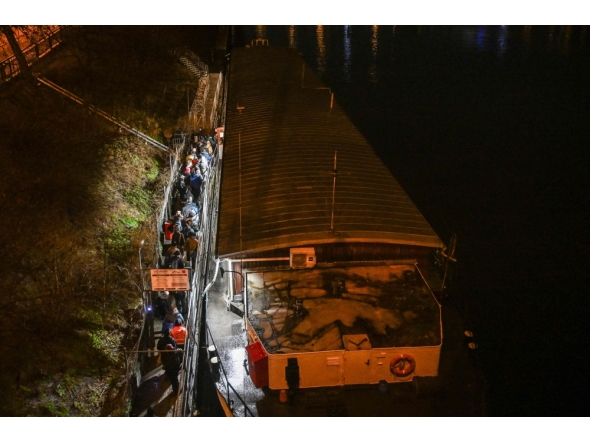 People wait in front the entrance to the cargo boat named 