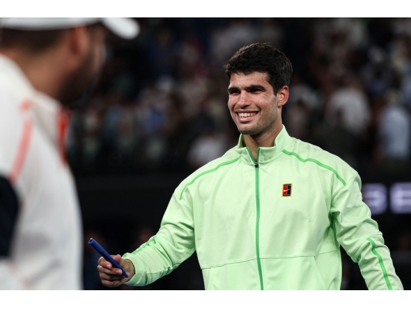 Spain's Carlos Alcaraz signs a television camera after beating Germany's Alexander Zverev in Melbourne on January 30, 2026. (Photo by Izhar Khan / AFP) 