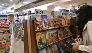 This photograph taken on January 20, 2026 shows a woman checking books by India's oldest and indigenous comic publisher Amar Chitra Katha at a store in Mumbai. (Photo by Indranil Mukherjee / AFP)