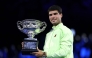 Spain's Carlos Alcaraz poses with the Norman Brookes Challenge Cup after defeating Serbia's Novak Djokovic in Melbourne on February 1, 2026. (Photo by Martin Keep / AFP)