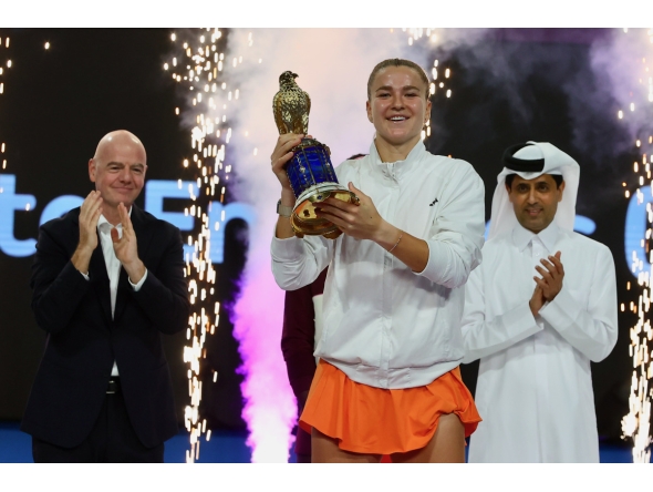 Karolina Muchova celebrates with the winner's trophy. QTSBF President Nasser Al Khelaifi and FIFA President Gianni Infantino are also present.