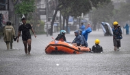 Local residents move hotel guests using a rubber boat through the water on an inundated street amid floods following heavy rain at Legian Kuta near Denpasar on Indonesia's resort island of Bali on February 24, 2026. (Photo by SONNY TUMBELAKA / AFP)
