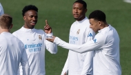 Real Madrid's Brazilian forward #07 Vinicius Junior (L) talks with Real Madrid's French forward #10 Kylian Mbappe (R) during a training session on the eve of their UEFA Champions League knockout round play-off second leg football match against SL Benfica at Santiago Bernabeu Stadium at Real Madrid Sports City in Valdebebas, in the outskirts of Madrid on February 24, 2026. (Photo by Oscar DEL POZO / AFP)