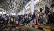 Passengers prepare to board a train to return home ahead of Eid al-Fitr, at Gubeng station in Surabaya on March 17, 2026. (Photo by Juni Kriswanto / AFP)