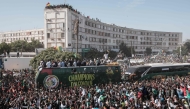 (Files) Supporters cheer as the Senegalese football players ride on a bus during a trophy parade in the streets of Dakar on January 20, 2026. (Photo by Guy Peterson / AFP)
