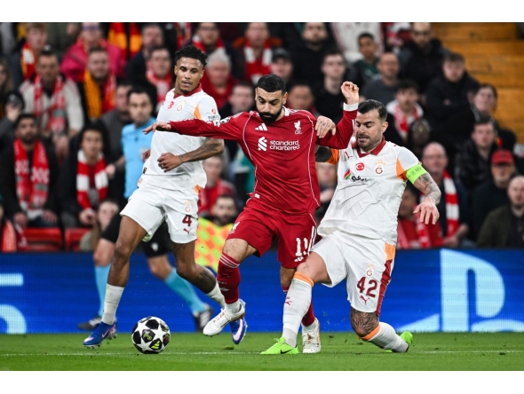 Liverpool's Egyptian forward #11 Mohamed Salah (C) fights for the ball during the UEFA Champions League, round of 16 second leg football match between Liverpool and Galatasaray on March 18, 2026. (Photo by Paul ELLIS / AFP)