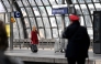 A traveller with suitcase and a train conductor walk along a platform at the main train station (Hauptbahnhof) in Berlin on March 27, 2026. Photo by RALF HIRSCHBERGER / AFP