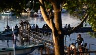 People fish at a pier near Denpasar on Indonesia's resort island of Bali on April 12, 2026. (Photo by SONNY TUMBELAKA / AFP)