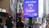 Tourists walk past a “Welcome BTS” sign in Myeong-dong, central Seoul, on Friday, a day ahead of the group’s comeback concert. (Lee Sang-sub/The Korea Herald)